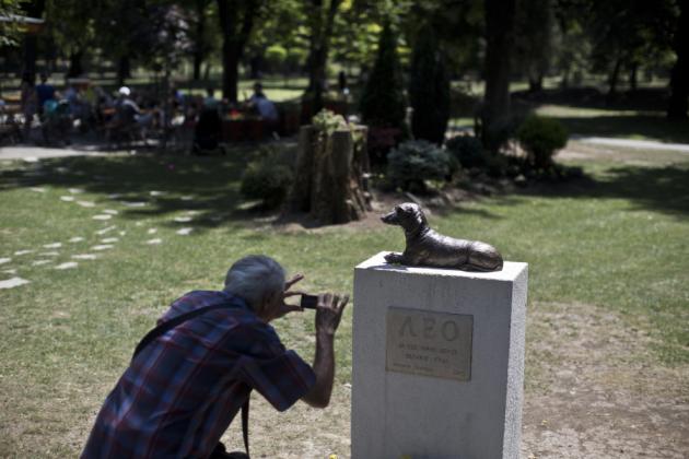 Un hombre fotografía el monumento a Leo, un perro salchicha que defendió con su vida a un niño del ataque de otro perro, en un parque público en Pancevo, a 12 kilómetros al este de Belgrado, Serbia el viernes 3 de julio de 2015. La leyenda en el monumento dice: "Leo, para todos los pequeños héroes con grandes corazones", en serbio. (Foto AP/Marko Drobnjakovic)