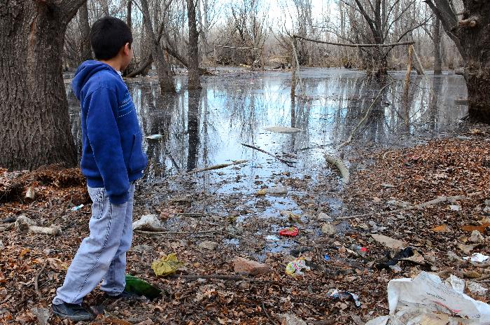 Neuquen 27/07/2015 preocupacion por la crecida del rio.Jose,El hijo de Jose y romina mira la canchita de futbol que ya quedo bajo el agua. viven en confluencia rural ceci maletti