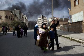 FILE - A family escapes from fierce fighting between Free Syrian Army