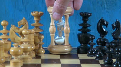 stock-footage-wooden-chess-pieces-on-chessboard-and-sandglass-hourglass
